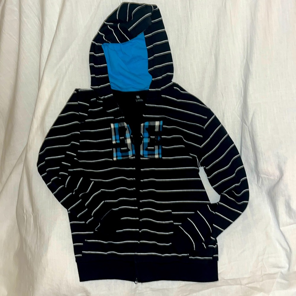 DC zip up hoodie. Black with white stripes. Logo is blue plaid. Boys M. Like New